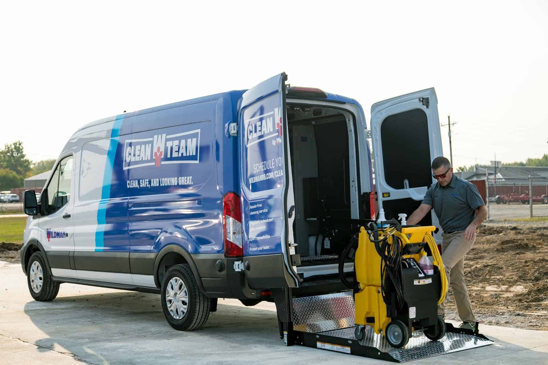 Cleanteam member loads gear into a blue service van with open doors.