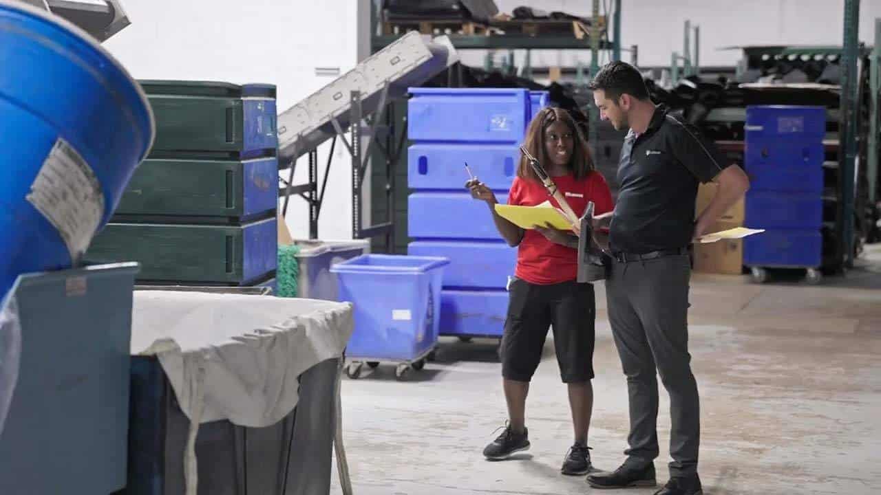 Two people discussing career paths in an industrial warehouse setting.