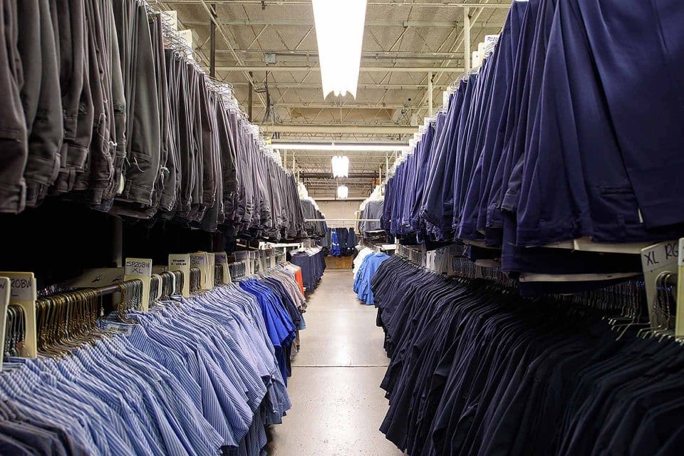 Aisle lined with racks showcasing the wildman difference in shirts and pants.