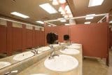 Public restroom with multiple sinks and stalls.