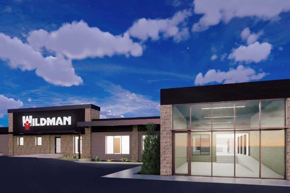 Modern commercial building with WILDMAN sign under a partly cloudy sky.