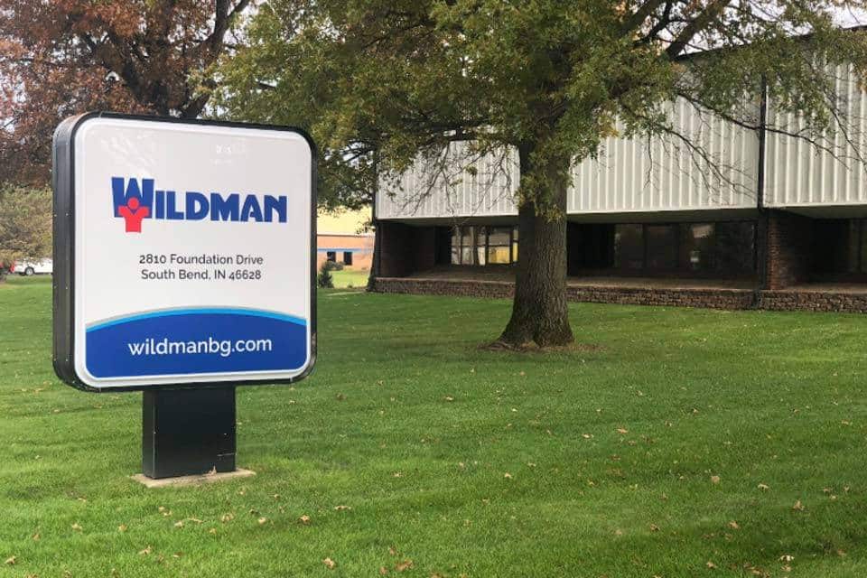 Wildman company sign in front of an office building with a tree and grass.