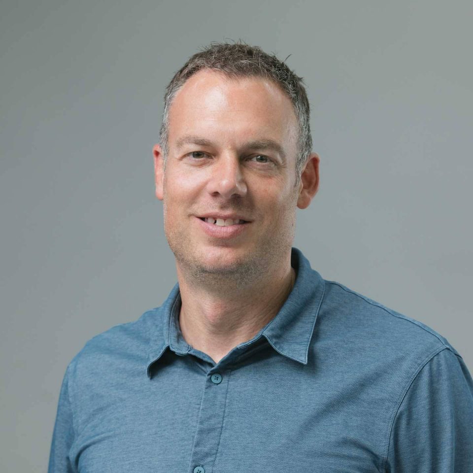 Headshot of a smiling man in a blue polo shirt.